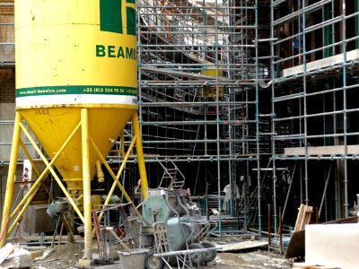 View 1. on new urban architecture arising - a building site and construction activities with scaffolding equipment, yellow cement-silo and building materials in Amsterdam-Oost; 2013 city photo - urban photography by Fons Heijnsbroek photo