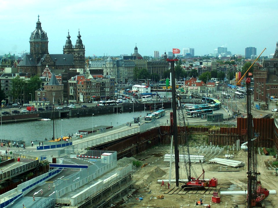 2007.08 - 'View on the city center' Amsterdam photos and pictures, the large excavation-site on Oosterdok with piling plants - to the left the old city and St. Nicolas church; Dutch city + geotag, Arjan Heijnsbroek, The Netherlands