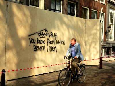 2015.04 - Amsterdam photo of street-art & light - A wall-writing, a cyclist and shadows on the wooden fence, street Keizersgracht; a geotagged free urban picture, in public domain / Commons CCO; city photography by Fons Heijnsbroek, The Netherlands photo