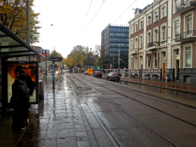 Free photo of Amsterdam: picture of waiting for the tram in the rainy street Sarphatistraat / Weesperplein, in the light of October, The Netherlands