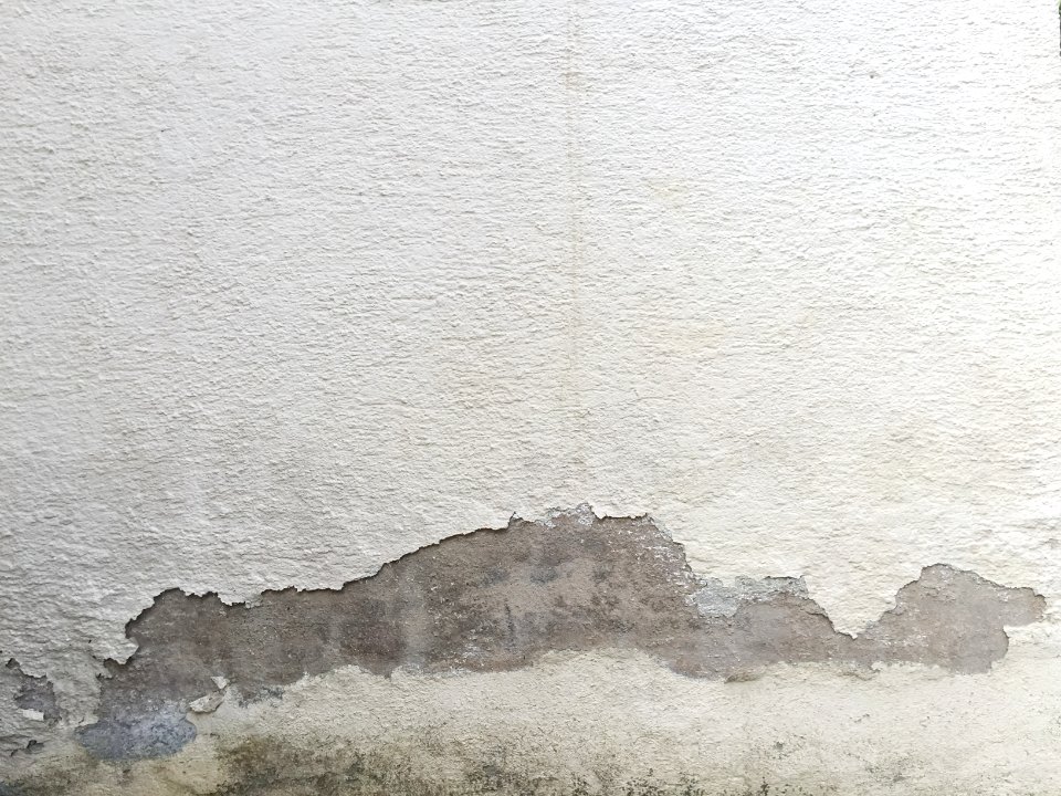 White plastered wall with cracks photo