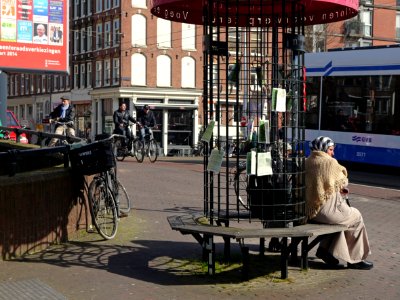 2014.03 - Amsterdam photo, Two women. sitting on street furniture in the sun-light, Kinkerstraat; a geotagged free urban picture, in public domain / Commons CCO;  city photography by Fons Heijnsbroek, The Netherlands