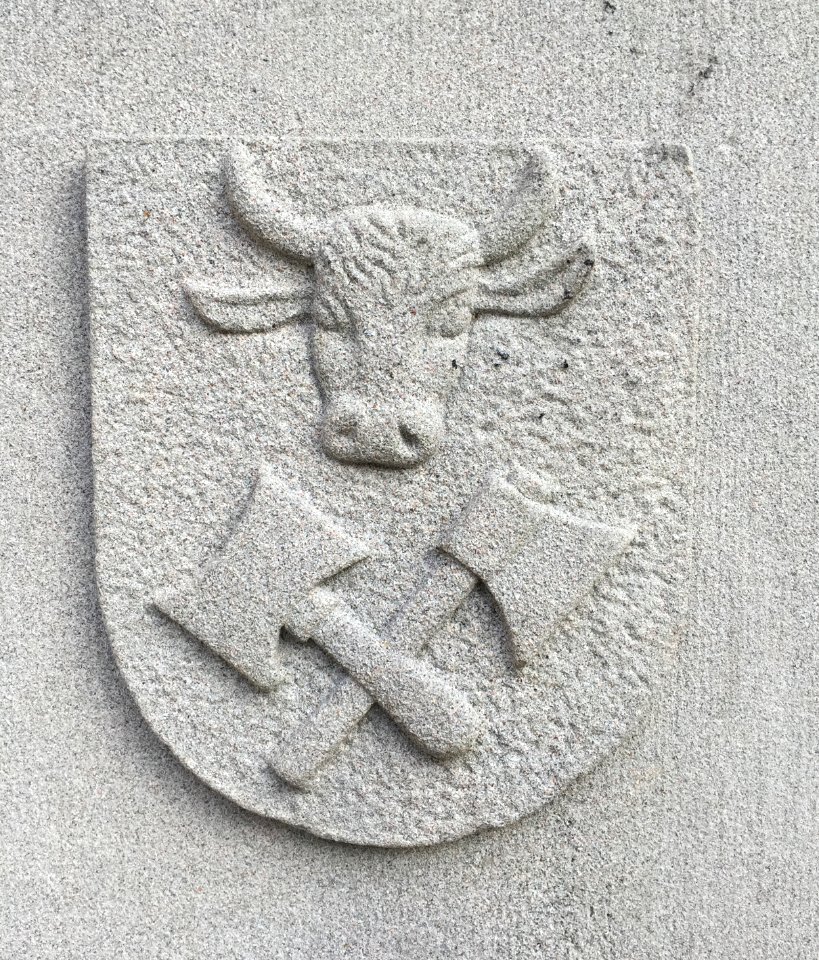 Stone mural with cow and axe
