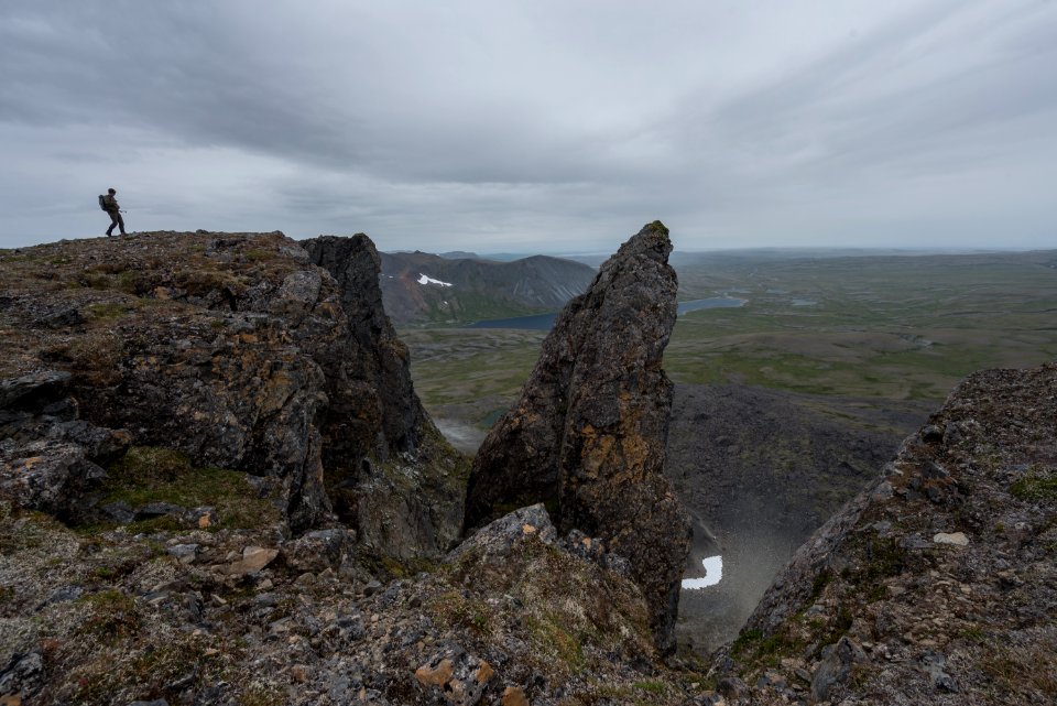 A hiker stands on a mountain summit, Katmai Preserve NPS Photo/Russ Taylor