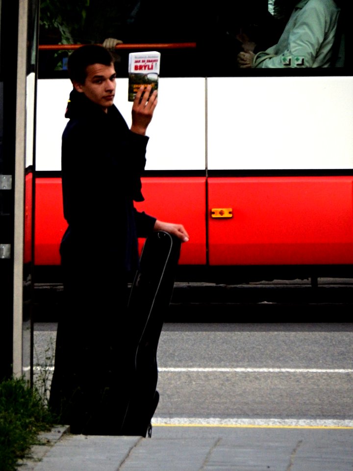 Young Man with a Book "How to Get Rid of Glasses" Looking at Annoying Photographer