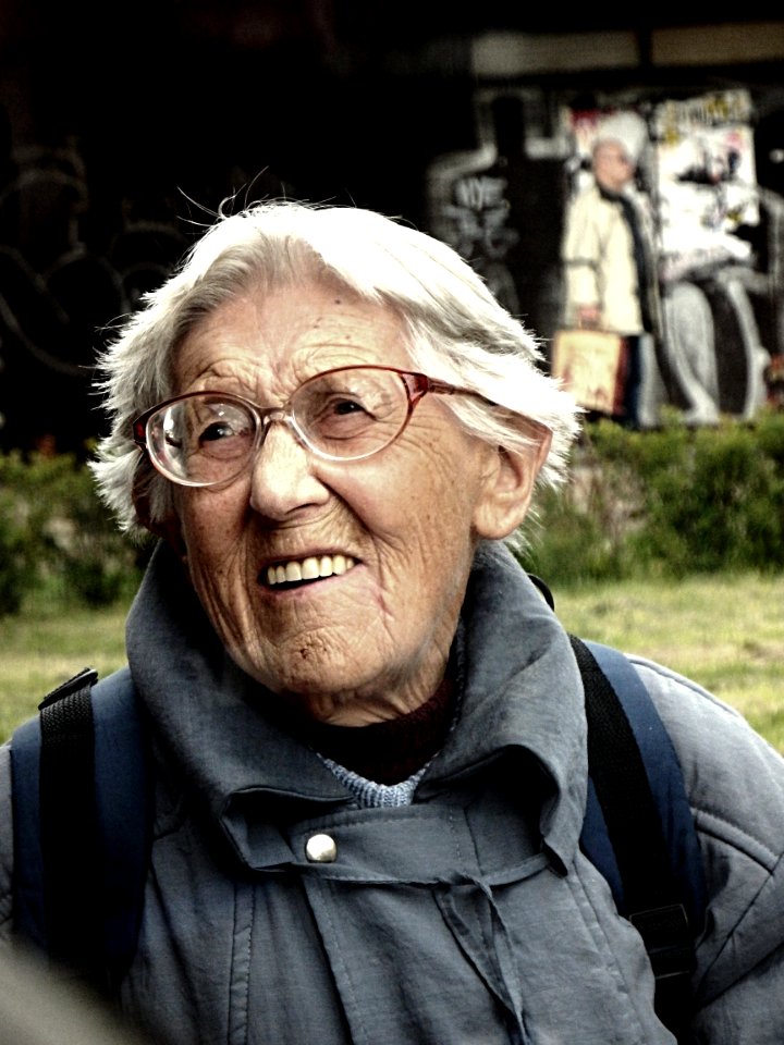 Old Woman Standing next to the Bus