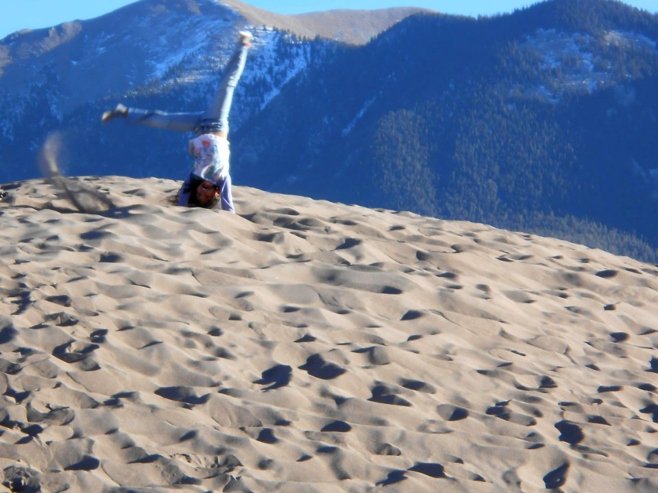 Girl Doing a Cartwheel on Top of a Dune