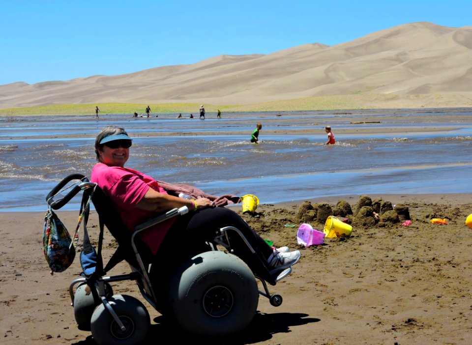 Woman in Dunes Wheelchair Next to Medano Creek