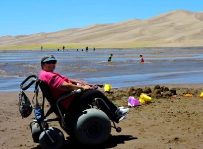 Woman in Dunes Wheelchair Next to Medano Creek