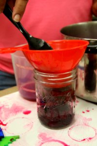 Using funnel to pack beets into jar photo