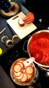 Placing lids on strawberry jam