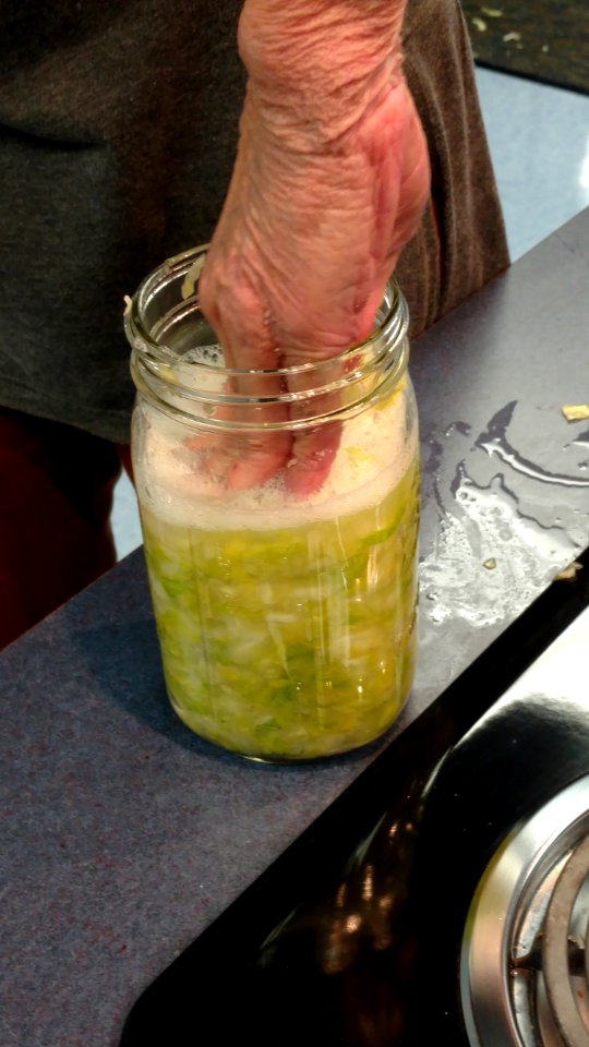 Pressing cabbage down into mason jar