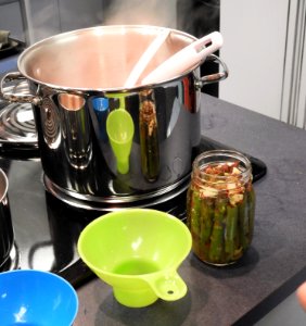 Filling pickled asparagus jars with brine photo