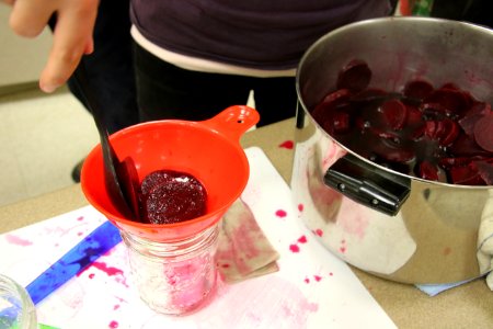 Adding beets to jars from pan photo