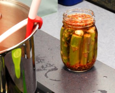 Pickled asparagus in jar before rim is wiped and lid added photo