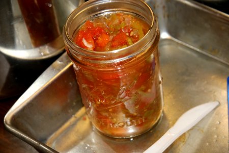 Jar of salsa being readied for canning photo