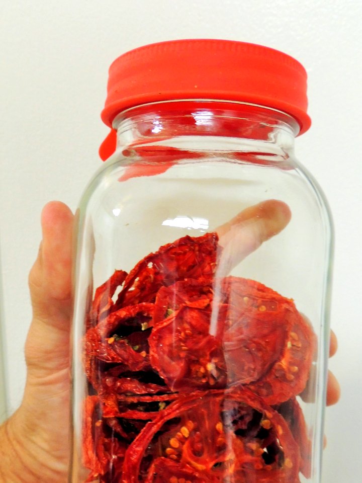 Holding jar of conditioning tomatoes