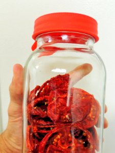 Holding jar of conditioning tomatoes photo