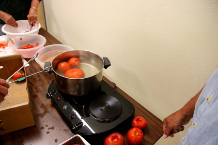 Dipping tomatoes in boiling water to more easily remove skins photo