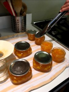 Covering clean, wiped jars with lids photo