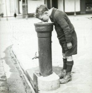 Boy drinking from Fountain Pipe c1920