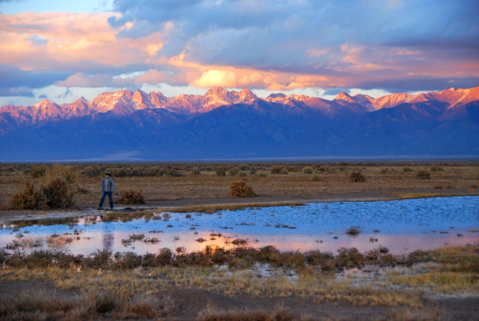Boy Walking Beside Small Wetland, Sunset on Sangre de Cristo Mountains