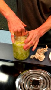 Compacting cabbage down into mason jar photo