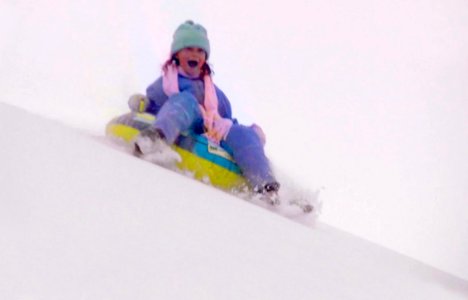 Girl Snow Sledding on Dunes