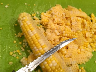 Using knife to remove kernels from the cob photo