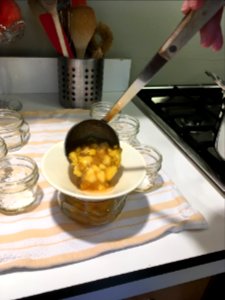 Filling jars with peach jam