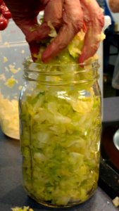 Filling mason jar with shredded cabbage
