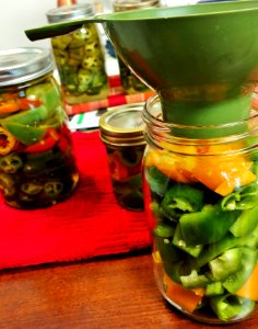 Jars of pickled peppers being prepared