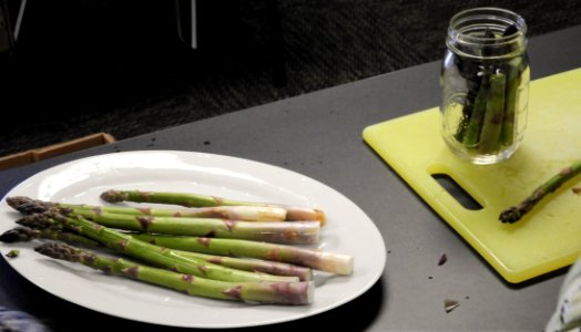 Packing fresh asparagus into canning jar photo