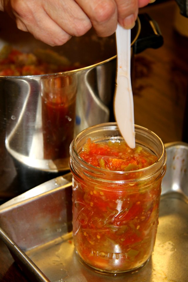 Using plastic knife to remove air bubbles prior to canning photo