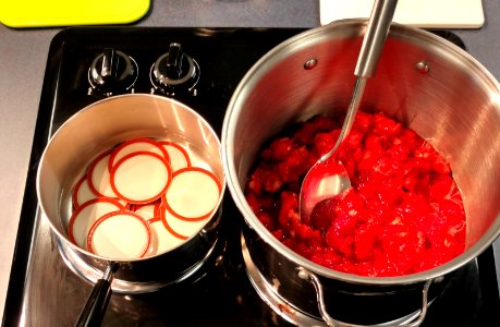 Heating lids and cooking strawberries photo