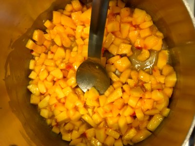 Peaches cooking with pectin, lemon juice, and butter