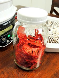 Dried tomatoes conditioning in mason jar photo