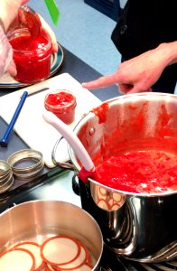 Filling canning jars with jam photo
