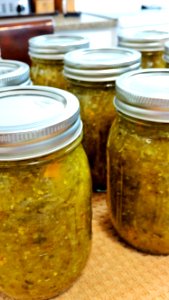 Jars of pickle relish cooling with rings on photo