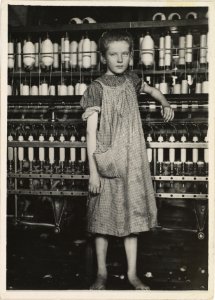 Child Labor:  A barefoot girl works in a New England textile mill, 1910.