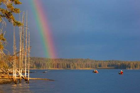 Canoeists paddling toward a rainbow