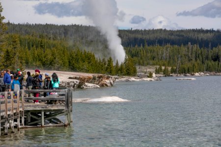 Shoreline of West Thumb Geyser Basin with geyser erupting in background