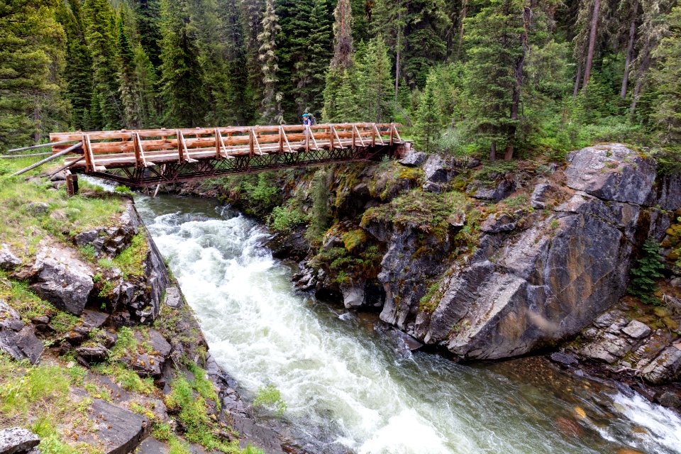 Backpacker crosses the Hellroaring Creek Bridge in the Absaroka Beartooth Wilderness