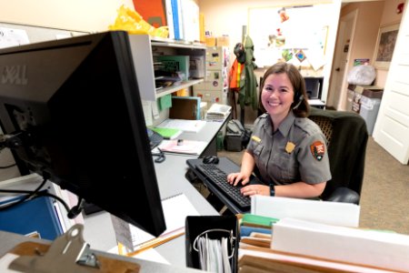 Heather answering phones and email in the Visitor Services Office