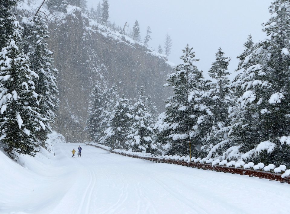 Skiers at overhanging cliff