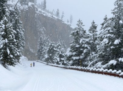 Skiers at overhanging cliff