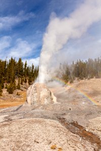 Fall morning Lone Star Geyser eruption with rainbow (portrait)