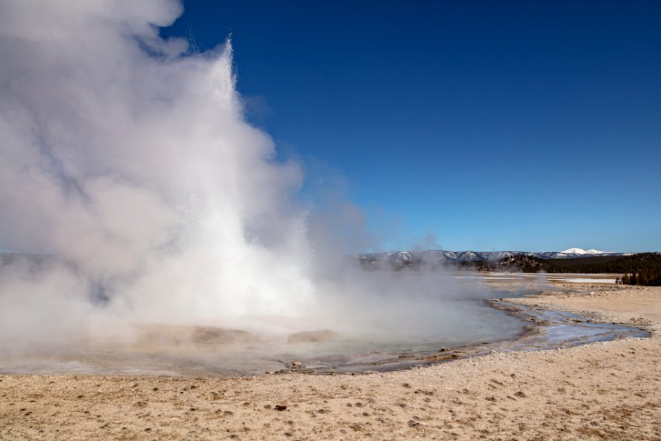 Fountain Geyser erupting with a snowy Mt. Holmes in the distance
