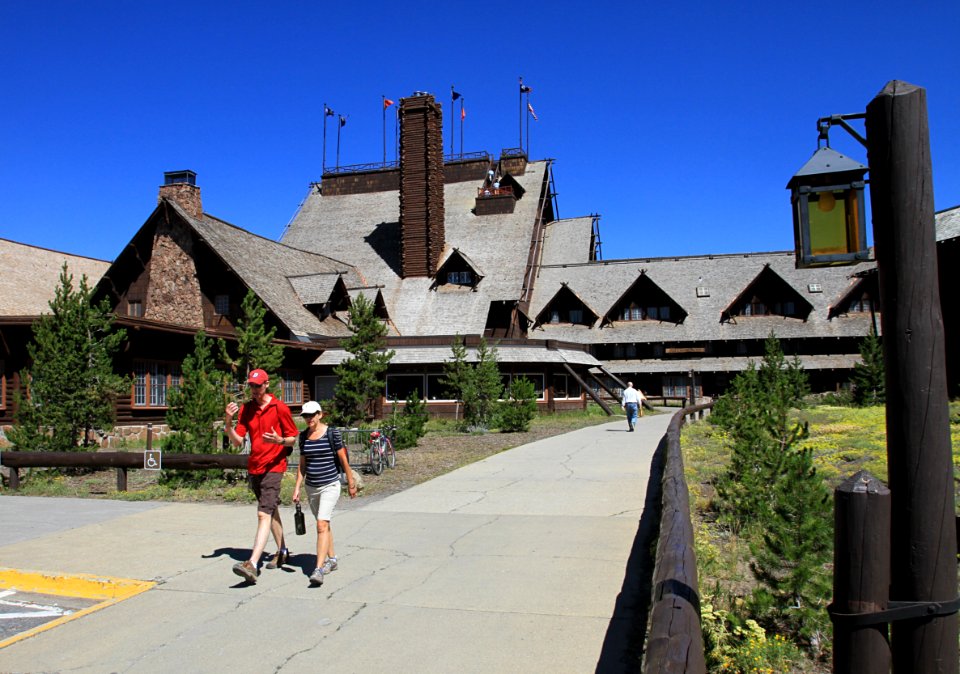 Old Faithful Inn, visitors walking on sidewalk behind the Inn