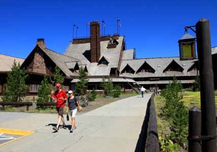 Old Faithful Inn, visitors walking on sidewalk behind the Inn